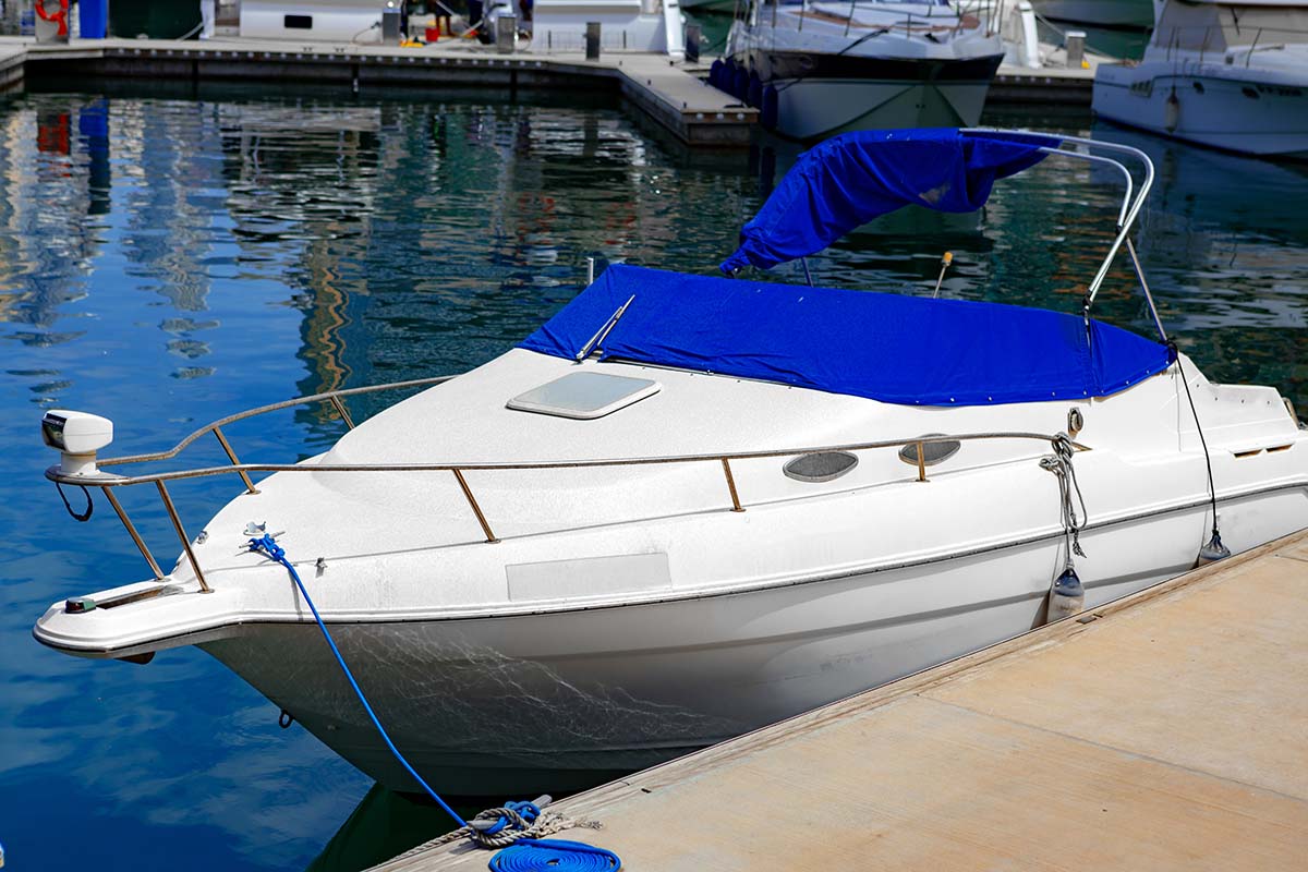 A boat at a San Diego dock with a blue Bimini top fitted