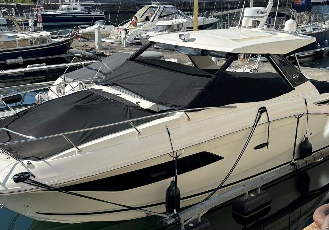 A boat at a marina with its canvas covers fitted